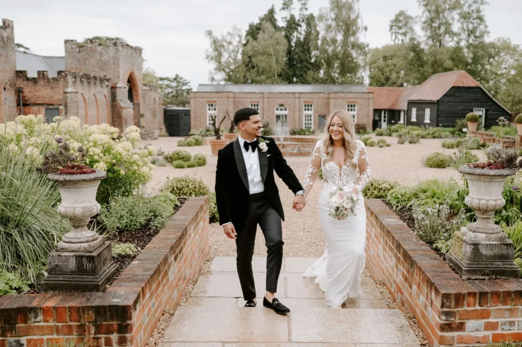 Bride and Groom walking through The Castle Barn Courtyard